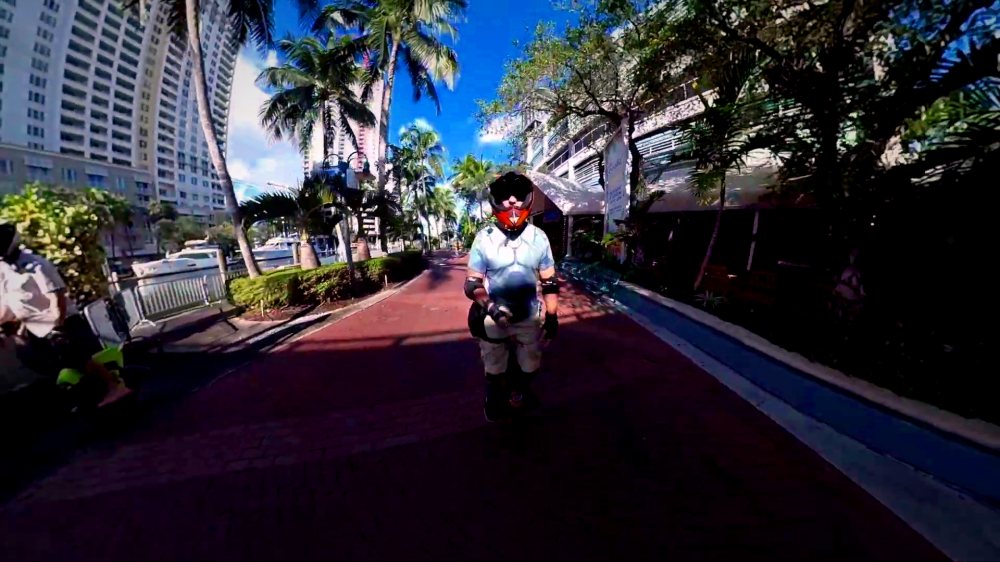 A rider on the Fort Lauderdale riverwalk beside the skyline.